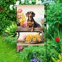 A beautiful black Dachshund dog surrounded by gorgeous flowers.