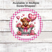 An adorable Scottish Highland Cow in a tub with heart balloons and pink gingham.