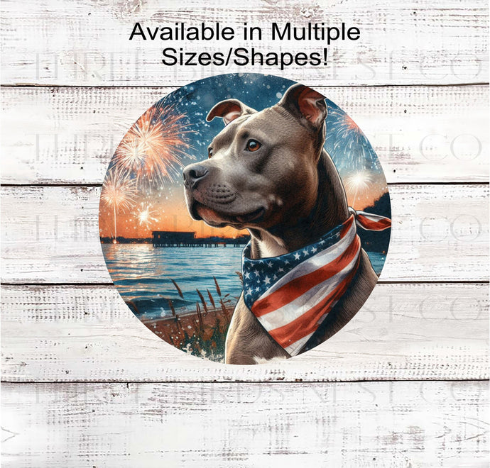 A beautiful Staffordshire Terrier/ Pit Bull dog wearing an American Flag Bandanna on a Beach with Fireworks.